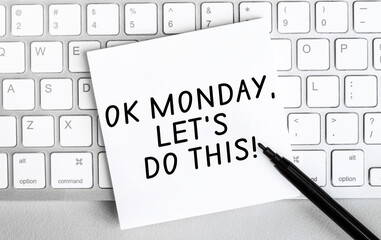 Poster - white paper with text ok monday lets do this lying on the keyboard