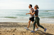 © Westend61 - Happy couple running and having fun at beach