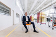 © Westend61 - Businessman sitting on chair in factory
