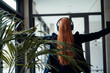 © Westend61 - Redhead businesswoman enjoying listening to music at office