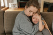 © Westend61 - Mother consoling crying daughter on sofa