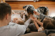 © Westend61 - Family stroking Australian Shepherd at home