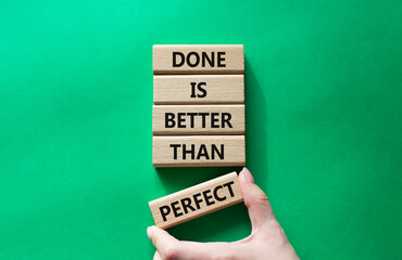 Wall Mural - Done is better than Perfect symbol. Wooden blocks with words Done is better than Perfect. Beautiful green background. Businessman hand. Business and Done is better than Perfect concept. Copy space.
