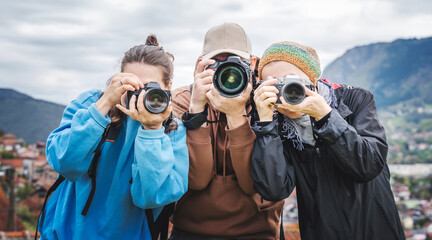 Group of young adult people friends colleagues professional photographers take photo on camera outdoor