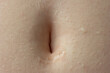 Young woman's belly button. Macro close up shot, unrecognizable person