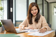 © Wasana - Confident entrepreneur lady sitting at working in office. Portrait businesswoman analyzing statistics