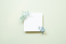 White Memo Card With Blue Flower On Mint Background. Top View, Copy Space