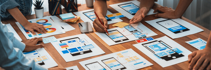 Poster - Panorama shot of front-end developer team brainstorming UI and UX designs for mobile app on paper wireframe interface. User interface development team planning for user-friendly UI design. Scrutinize