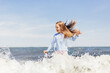 © Photocreo Bednarek - Young girl playing on the beach in waves at summer