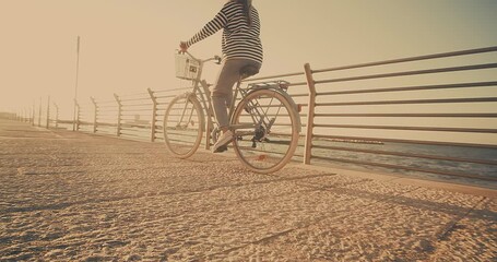 Wall Mural - Carefree woman with bike riding on beach having fun, on the seaside promenade on a summer day. Summer Vacation. Travel and lifestyle Concept.