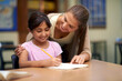© Mapodile M/peopleimages.com - School, education or study with a student and teacher in a classroom together for writing or child development. Learning, scholarship and teaching with a woman educator helping a girl child in class
