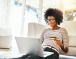 Young woman, laptop and credit card in living room doing online shopping sitting on ground. Home, happiness and computer of African female person on a internet ecommerce app reading online deal