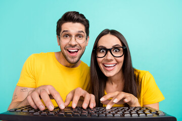 Photo of overjoyed funny excited nerd geeks writing keyboard looking display surprised unexpected good search isolated on aquamarine color background