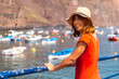 © unai - A tourist woman looking at the beach from the fishing port of Valle Gran Rey village in La Gomera, Canary Islands