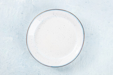 An empty white plate with a blue rim, overhead flat lay shot on a slate background, the concept of food