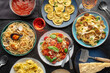 Pasta variety. Italian food and drinks, overhead flat lay shot on a black background. Spaghetti marinara, mushroom pappardelle, seafood pasta etc