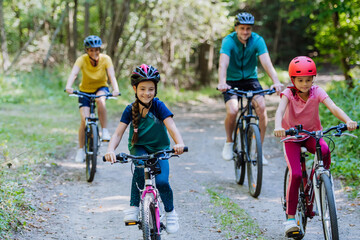 Wall Mural - Young family with little children at bike trip together in nature.