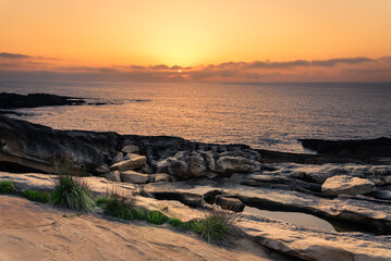 Wall Mural - Seascape of a beautiful rocky coast under a colorful sky at sunset, Hondarribia, Guipuzcoa, Basque Country, Spain