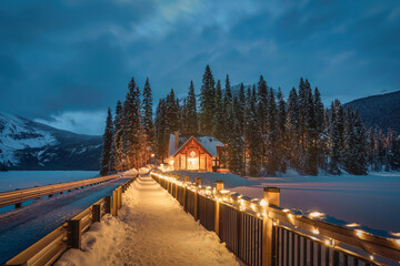 Wall Mural - Emerald Lake with wooden lodge glowing in snowy pine forest on winter at Yoho national park