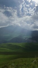 Wall Mural - Beautiful mountain landscape with sun rays and clouds, timelapse. Vertical video