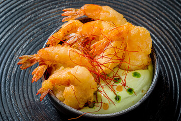 Canvas Print - Shrimp tempura on a plate placed against a black background.