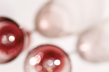 Wall Mural - two glasses of red wine blurred on light white background, abstract aesthetic photo of red wine, nat
