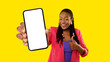 canvas print picture - African Lady Showing Cellphone Screen Gesturing Thumbs Up, Yellow Background