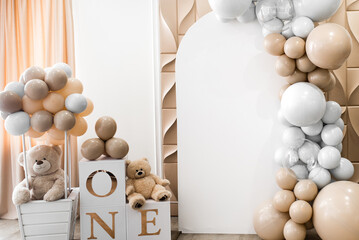 Arch decorated with golden, white balloons and soft teddy bears for birthday party. Celebration concept. Trendy decor. Copy space, place for text. Children's photo zone for girl 1 year and photo wall