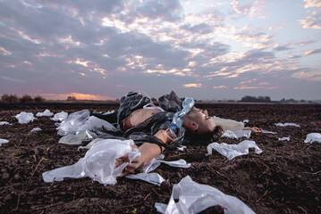 young man with athletic figure wrapped in plastic on the ground