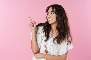 Poster - Young Asian woman pointing fingers up to empty space isolated pink color background