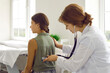 © Studio Romantic - Woman doctor is examining teen girl on chekup appointment using phonendoscope in clinic. They standing half-turned back to camera. Healthcare, child pediatrician, medicine, breath problems concept.