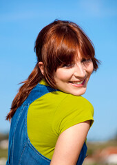 Wall Mural - Portrait of a happy beautiful woman over a blue sky