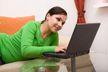 Poster - attractive brunette woman on sofa with laptop