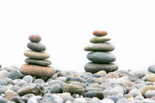 Two Stacks Of Stones Over White, Focus On The Left One