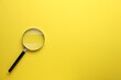 canvas print picture - Magnifying glass on yellow background, top view. Space for text
