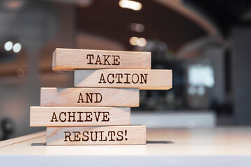 Wall Mural - Wooden blocks with words 'Take action and achieve results'.