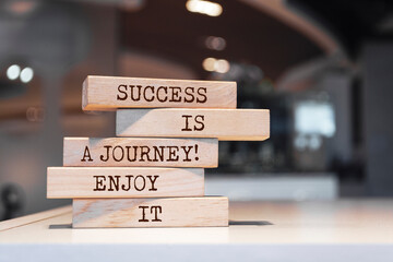 Wall Mural - Wooden blocks with words 'Success is a journey, enjoy it'.