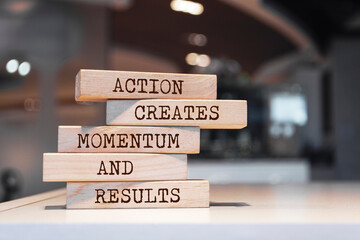 Wooden blocks with words 'Action creates momentum and results'.