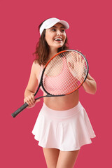 Wall Mural - Young woman with tennis racket on pink background
