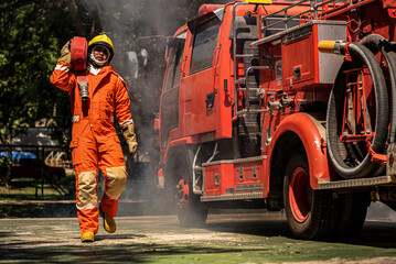 Wall Mural - With a firm grip on the fire hose the firefighter displays a sense of readiness prepared to combat the flames and provide assistance to those in distress.