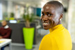 © Wavebreak Media - Portrait of smiling african american businesswoman with short hair looking over shoulder in office