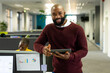 © Wavebreak Media - Portrait of bearded african american businessman with digital tablet standing in office, copy space