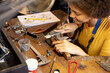 © Wavebreak Media - Happy biracial female worker making jewellery using tools at jewellery workshop