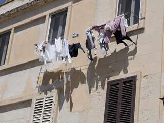 Sticker - clothes on balcony of ortigia syracuse old buildings street view Sicily on sunny day