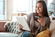 © Grady Reese/peopleimages.com - Happiness, online shopping and credit card, woman on sofa and mobile app on tablet, internet banking in home. Technology, cashback payment and happy girl on couch on retail website or digital shop.