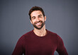 © Ruan J/peopleimages.com - Happy, handsome or headshot portrait of a man isolated on studio background with confidence or smile. Model, mock up space or face of male person smiling with happiness or positive mindset in Italy