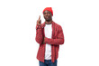 smart cute 30s black american man dressed in red shirt and cap communicates idea on white studio background with copy space