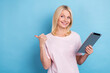 © deagreez - Portrait of cheerful nice pensioner woman wear white t-shirt hold tablet indicating look empty space isolated on blue color background