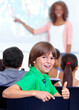 © Cameron Mcdonald/peopleimages.com - Thumbs up, teaching and child portrait for happy learning, support and thank you with education success, school or geography. Like, yes and achievement hand or emoji of boy kid with map in classroom