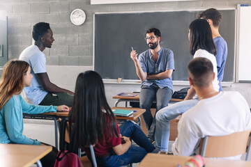 Teenager students and young male teacher sharing group discussion at School - Youth counselor advisor